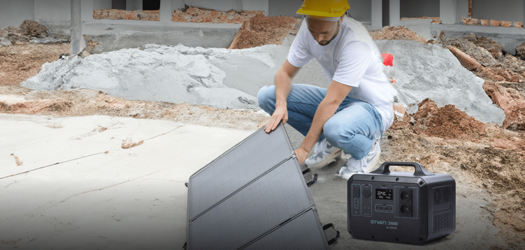 Un homme installe un panneau solaire sur un chantier, énergie verte, coût énergétique faible, économie d'énergie, Batterie IZYWATT 2400
